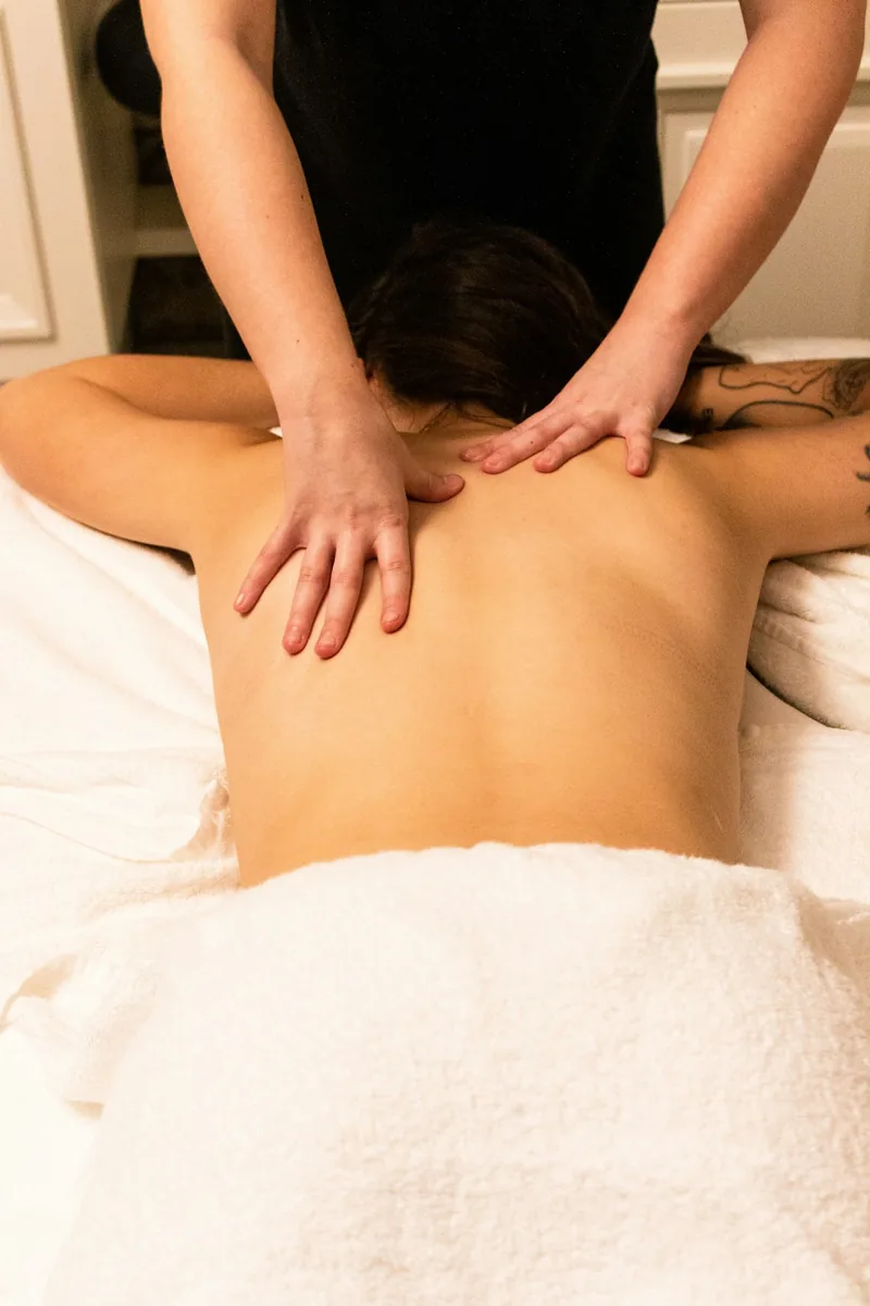Mans donant un massatge relaxant a l'esquena i el coll d'una clienta